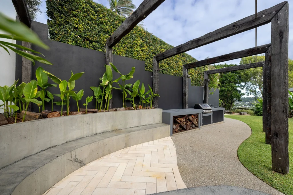 Outdoor barbecue area with concrete bench of a renovation in Lennox Head by Canstruct Builders.